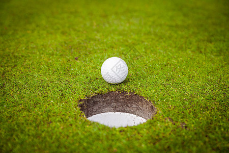 杯唇上的高尔夫球高尔夫球场绿草上的高尔夫球图片