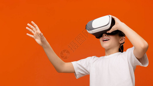 在现实生活中的创新情感青少年在橙色背景空地上享受虚拟现实图片