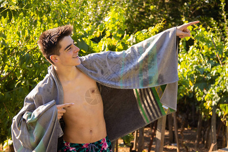 披沙滩巾或泳池毛巾的年轻少年图片