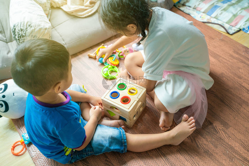 亚洲可爱的小孩在家中坐在木地板上玩具图片