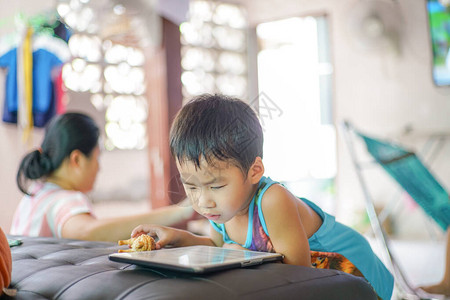 亚洲男孩玩平板电脑同互联网浏览器教育概念的计图片