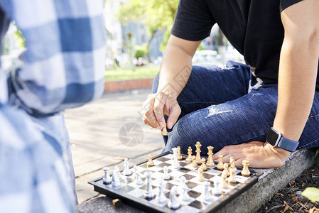 和他朋友一起玩象棋游戏时带着象棋图动起来的年轻人图片