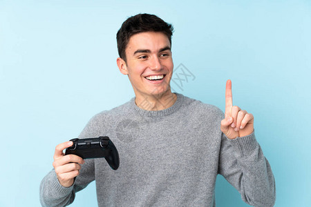 青少年caucasian男子与一个视频游戏控制器玩耍图片