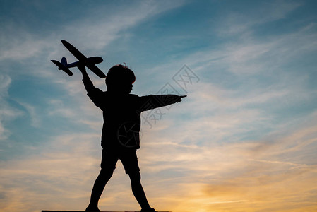 孩子与飞机在阳光下的剪影梦想和旅行的概念飞图片