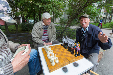 养老金领取者在一栋公寓楼的院子里下棋图片