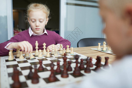 穿着紫色毛衣和白衬衫的女学生仔细考虑下棋要做什么样的动背景图片