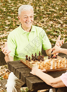 快乐的老人在公园下棋高清图片