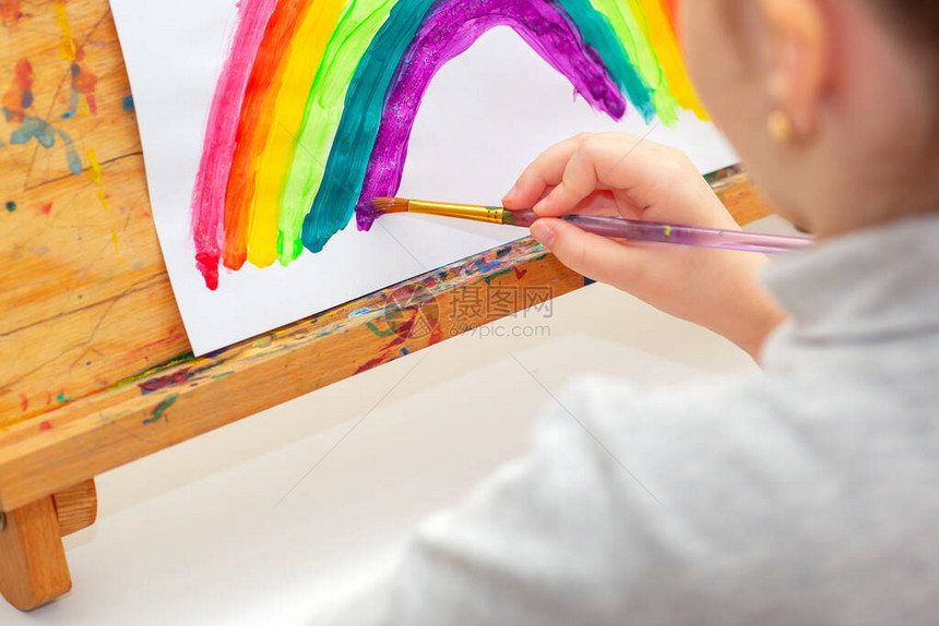 孩子正在画彩虹上面的纸上写着水彩色创造概图片