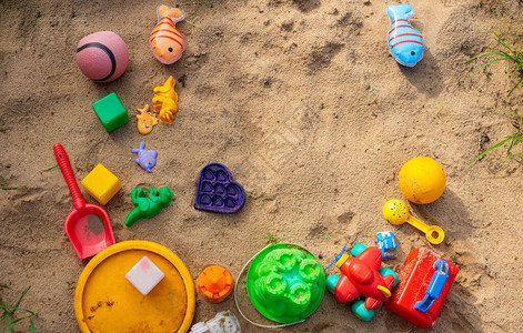 沙盒里躺着五颜六色的儿童塑料玩具图片