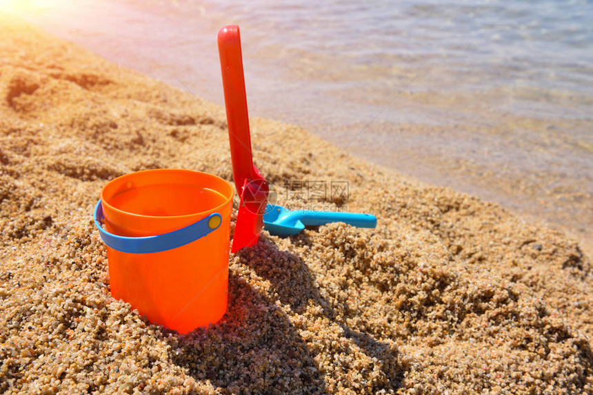 明亮的塑料儿童沙滩玩具海边沙滩上图片
