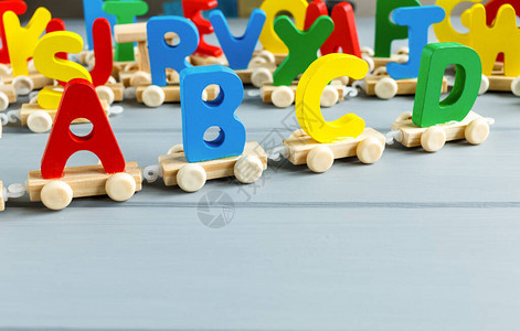 用灰色背景的ABC关闭五彩的木制字母一套学习字母表的玩具教育图片