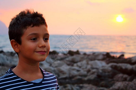 穿着条纹衬衫的小孩在日落时在岸边玩耍图片