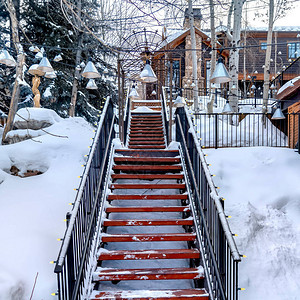 在雪坡上的广场台阶上有建筑物和树木图片