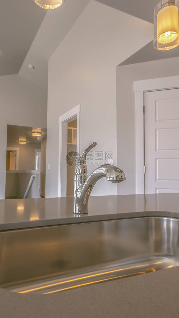 垂直框架将不锈钢水槽和水龙头放在新家的厨房里图片
