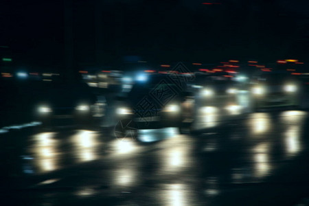 夜城里有车头灯和的汽车开着大灯的汽车交通信号灯路上的汽车图片