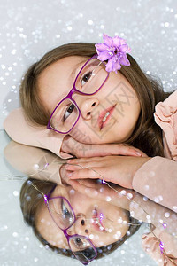 头发眼镜和倒影里装着花的小女孩图片