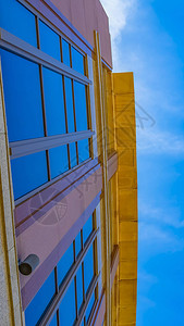 一栋商业大楼从下面对着光辉的蓝天看图片