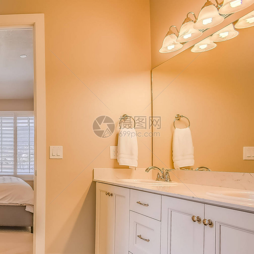 方形框架浴室内部配有内置浴缸淋浴间和梳妆区透过敞开的门可以看到卧室和带图片