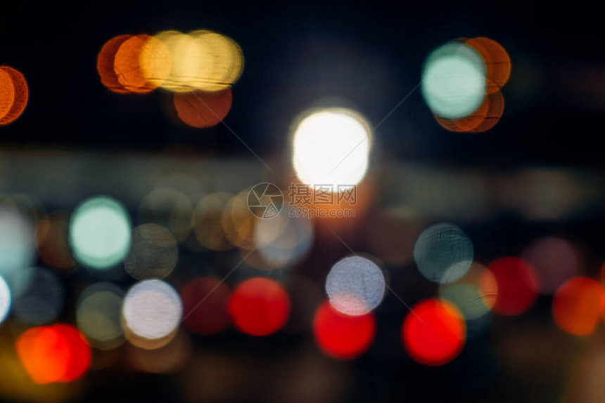 夜间城市街道的模糊背景与明亮的汽车前灯图片