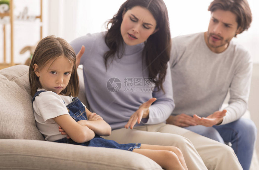顽皮的孩子恼怒的父母在家里一起坐在沙发上责骂他们的图片