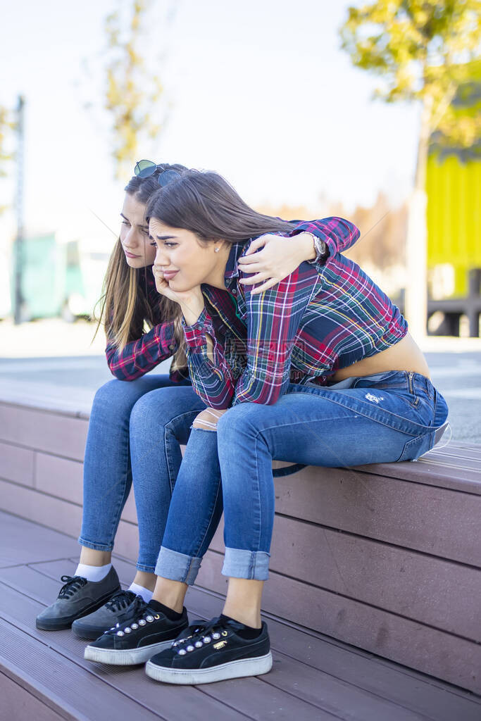 年轻女子在公园安慰一个图片