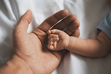 亲近的婴儿小手躺在父亲之手的男人身上背景图片