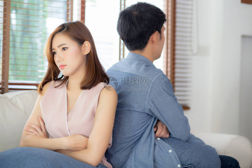 亚洲年轻夫妇在家客厅沙发上遇到问题图片