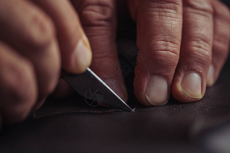 鞋匠用刀切割真皮的裁剪视图图片