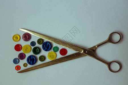 长裁缝的剪刀和不同颜色和尺寸的纽扣图片
