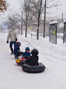 一位父亲带着他的三个孩子乘坐一辆由雪橇和两个安全气囊组成的蒸汽火车图片