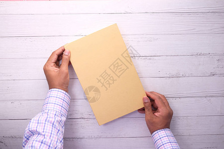 男人拿着白色空白封面的书背景图片
