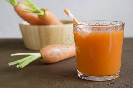 棕色背景上新鲜成熟的胡萝卜汁图片