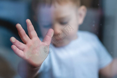 孩子的小手反射着按在窗玻璃上背景图片