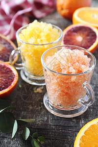 橙花岗两个杯子中冷冻的夏季甜点和新鲜橘子水果图片