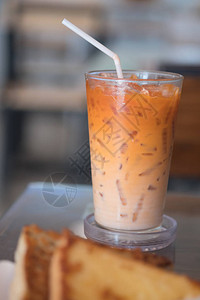 用稻草装在玻璃杯中的冰奶茶或泰式奶茶背景图片
