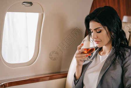 在私人喷气式飞机上拿着杯子和白兰地的有吸图片