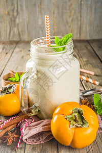 秋季健康饮料和小吃秋季时令柿子冰沙加香料肉桂茴香薄荷叶在质朴的图片