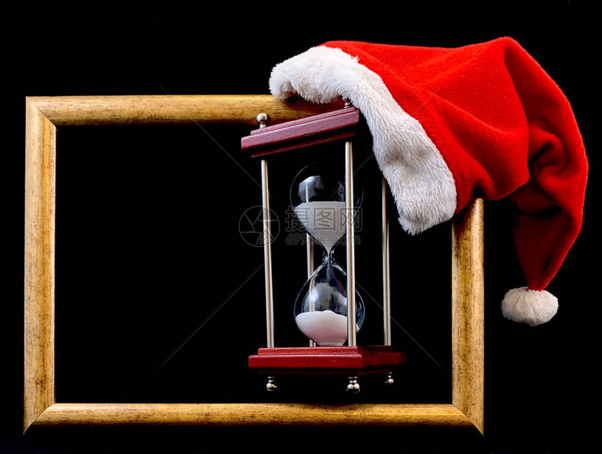 圣诞老人帽中的沙漏玻璃沙漏上的圣诞帽用于测量时间的玻璃装置图片