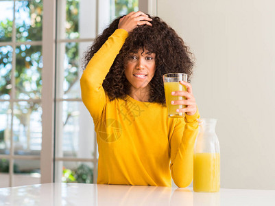 在家中喝健康果汁的非裔美国妇女头部压力过大图片