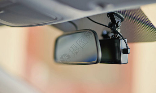 镜子近景后面的黑色行车记录仪像机背景图片
