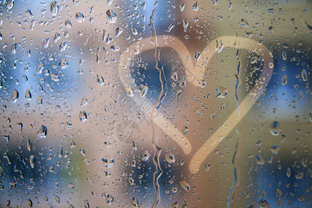 窗口上的雨滴与心脏模式关于爱和悲伤的概念照片图片