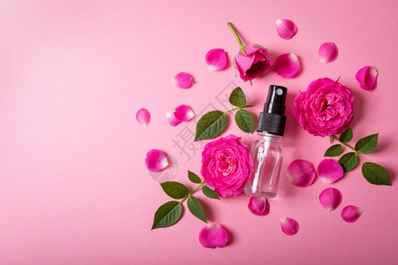 玫瑰香水喷雾粉红鲜花和瓣以粉红色背图片