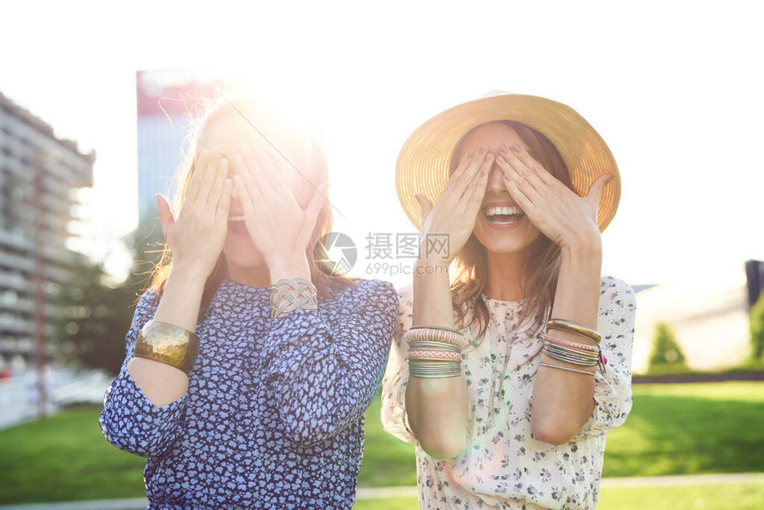 两个快乐的年轻女人用双手蒙着眼睛图片