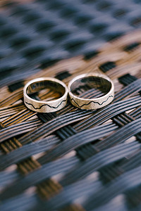 金婚环以灰色的编织纹理为模式图片