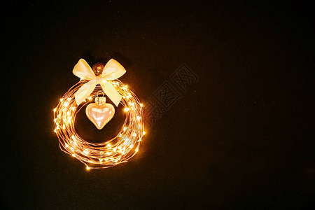 从花环上的发光圆圈以圣诞玩具的形式在黑色背景上闪发光图片