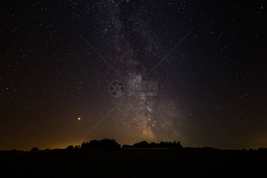 夜空中五颜六色的明亮银河与风景图片