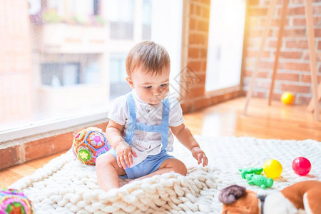 坐在毛毯上坐着的可爱的小孩儿在幼儿园图片