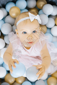 一岁女孩坐在玩具球背景图片