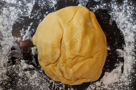 在烤盘上用面粉做糕点的面团图片
