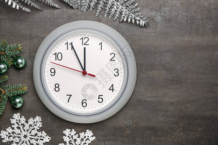 灰色背景上的时钟和圣诞装饰图片